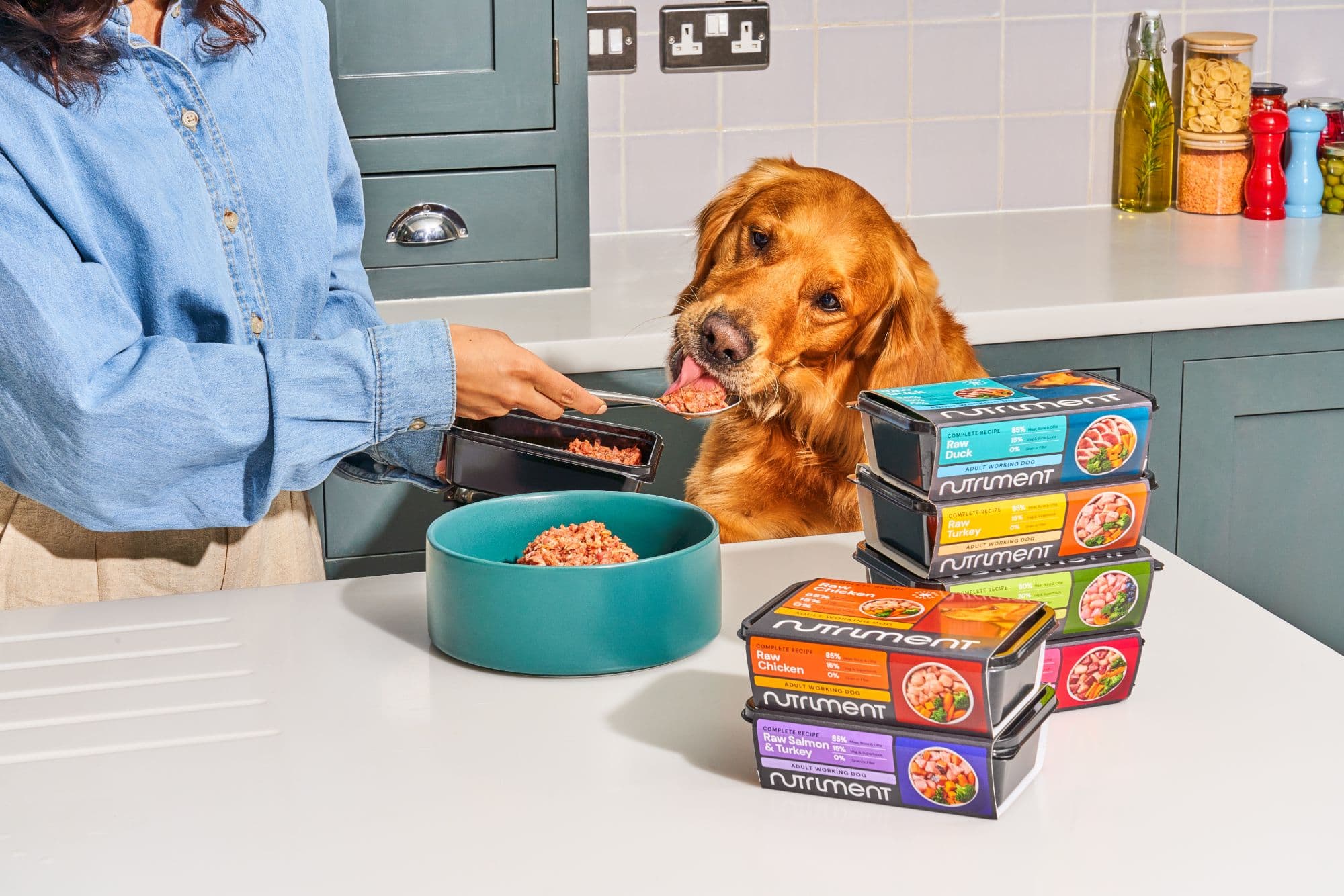 A golden retriever tasting Nutriment raw food from a spoon